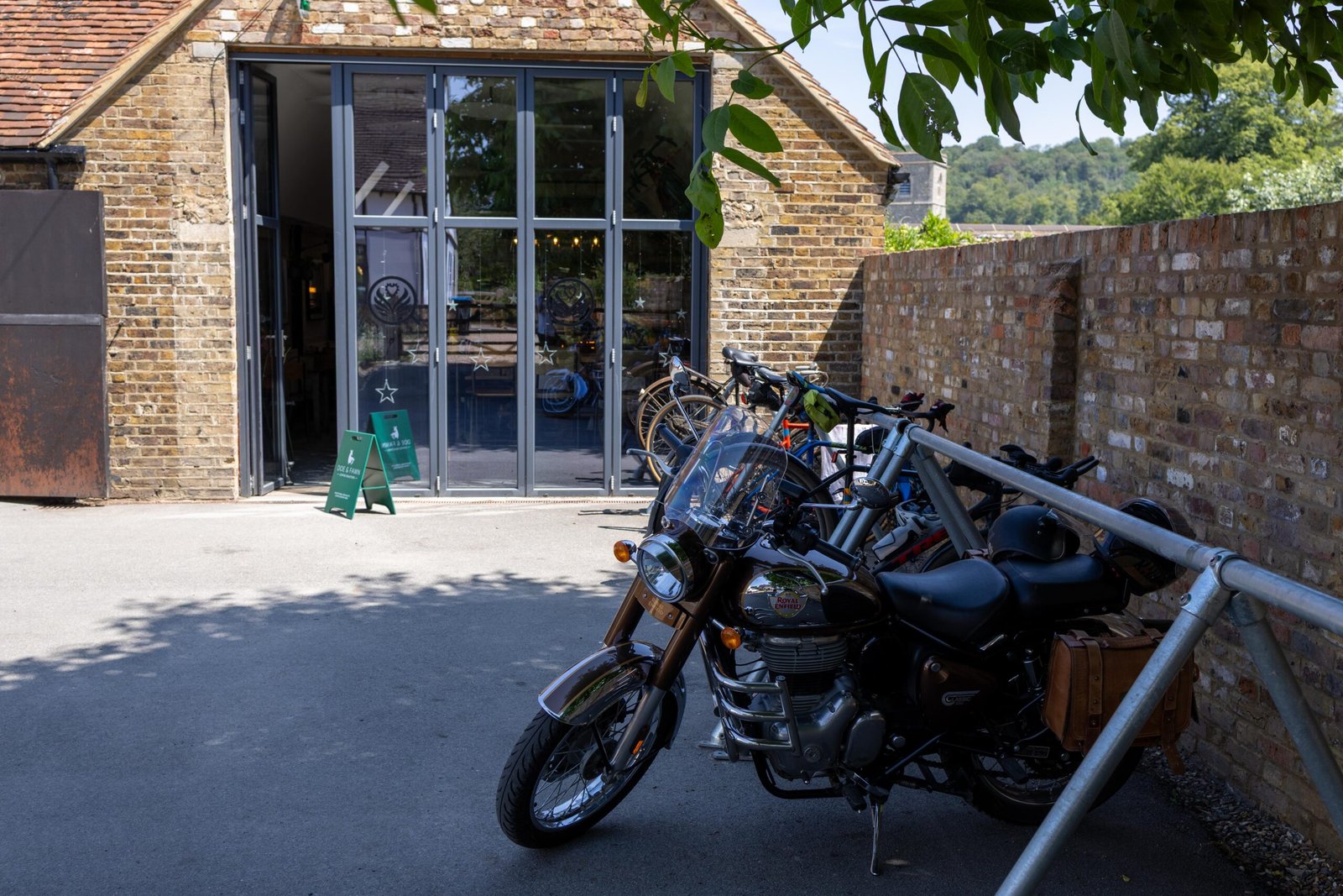 The converted barn housing Church Farm Café in Aldbury, motorcycle parked among the bicycles