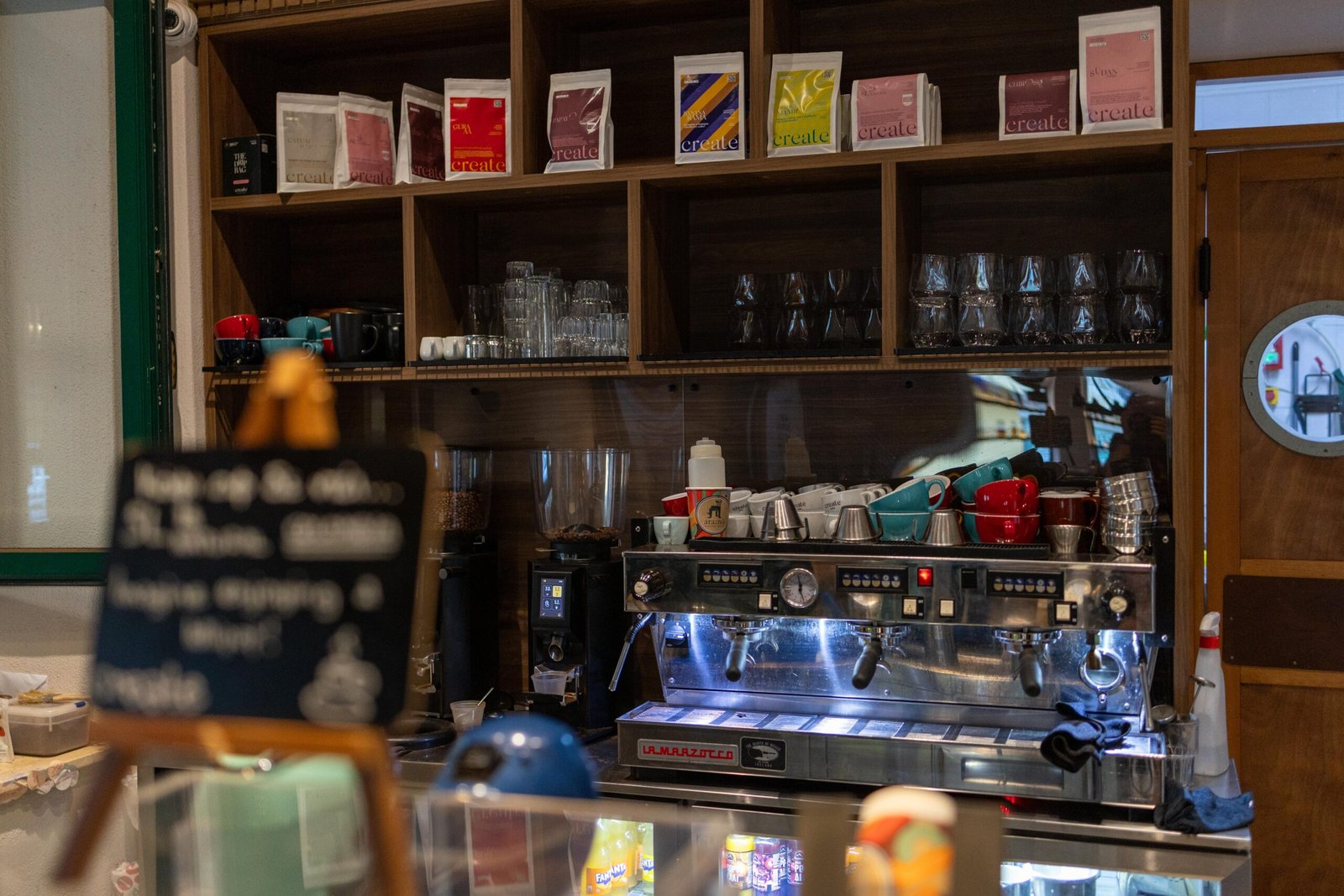 Bags of Create coffee on a shelf above the espresso machine at Ara:zo
