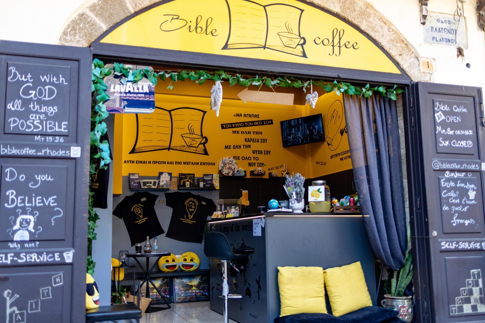 The entrance to Bible Coffee in Rhodes Old Town, with chalkboards reading But with God all things are possible