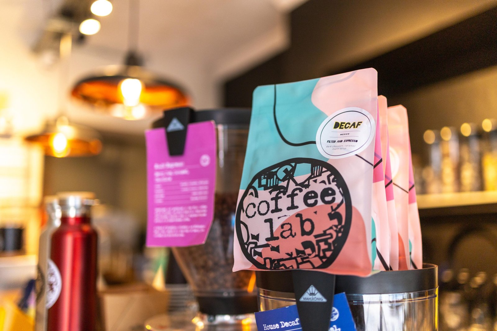 Coffee Lab decaf coffee bags in pink and teal packaging, roasted in Hertfordshire