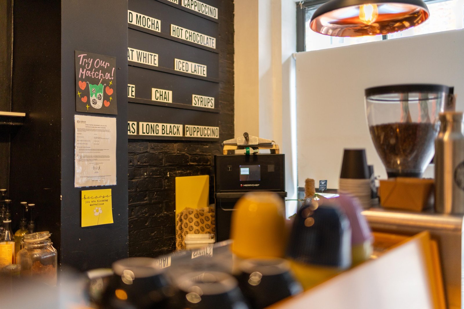 Hand-lettered menu board at Coffee Lab listing flat whites, chai, and a Puppuccino, with a matcha sign