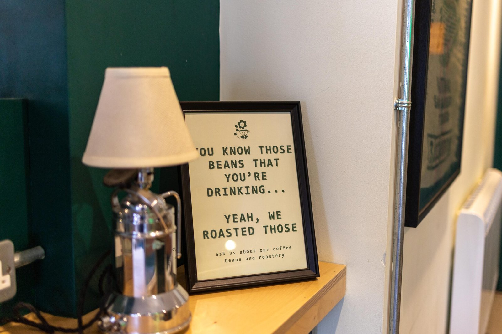A framed sign at Level Ground Co reading, you know those beans you're drinking, yeah, we roasted those