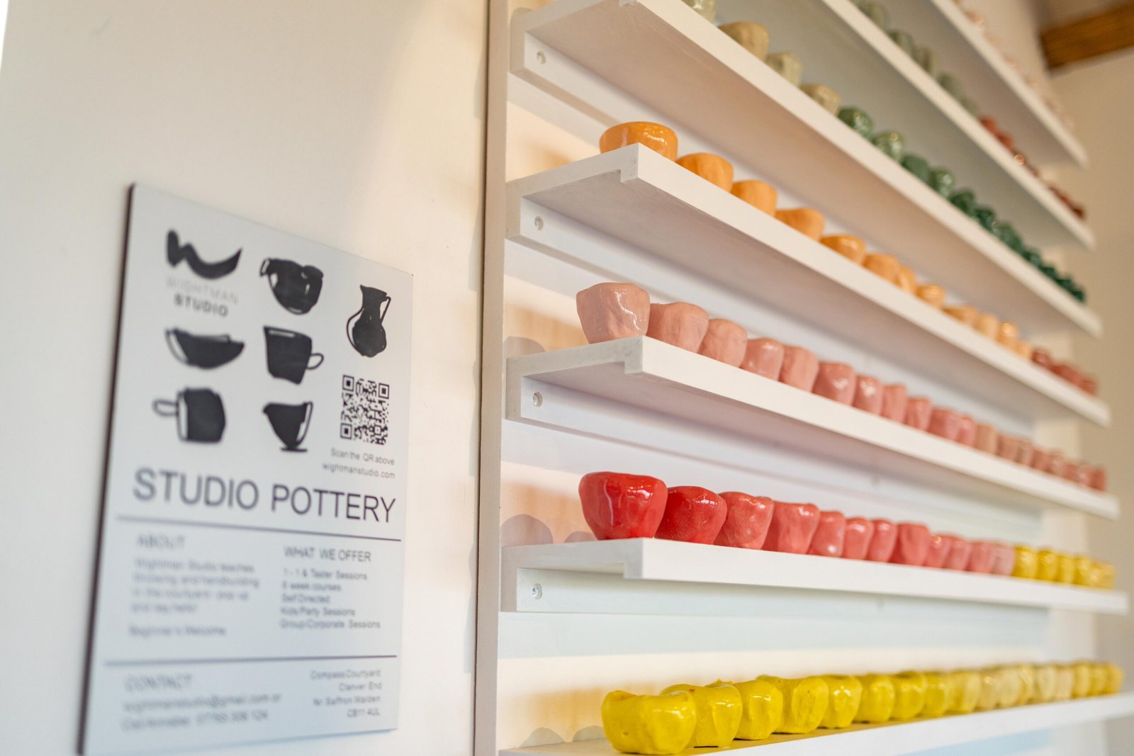 Wall of hand-thrown colourful pinch pots at Wightman Studio pottery, next to The Mixing Shed Cafe