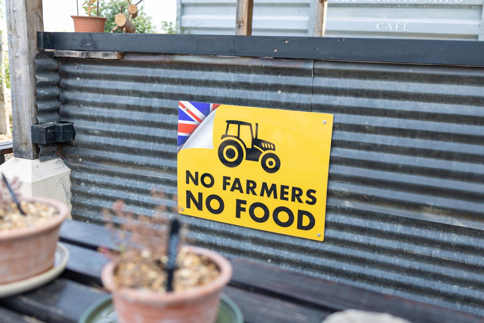A No Farmers No Food sign on corrugated metal siding at The Mixing Shed Cafe