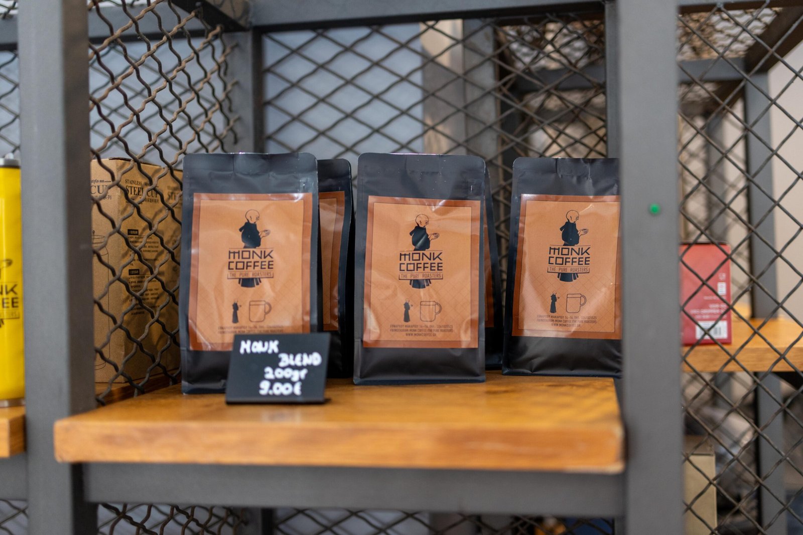 Bags of Monk Blend coffee for sale on a shelf at Monk Coffee, priced at 9 euros for 200 grams