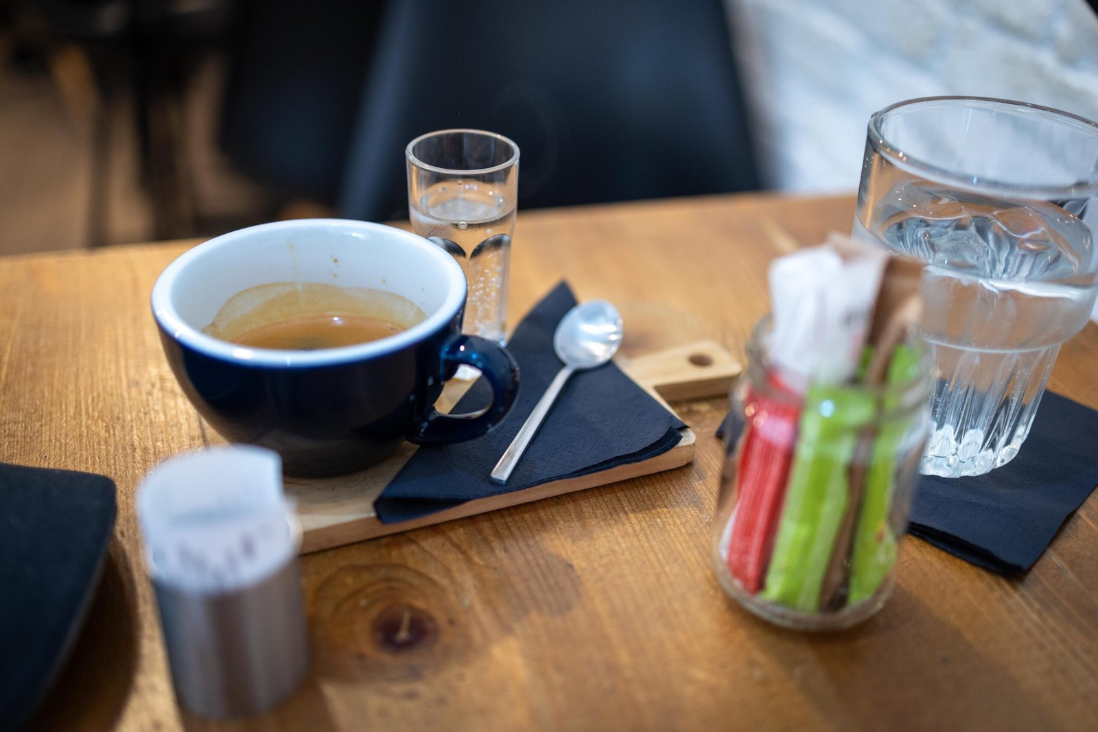 A double espresso served with a glass of water on a wooden table at Monk Coffee