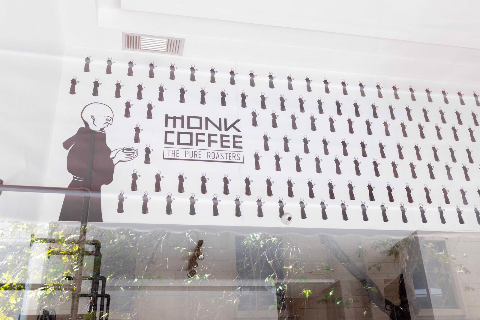 The Monk Coffee wallpaper viewed through the shop window from outside in Rhodes Town