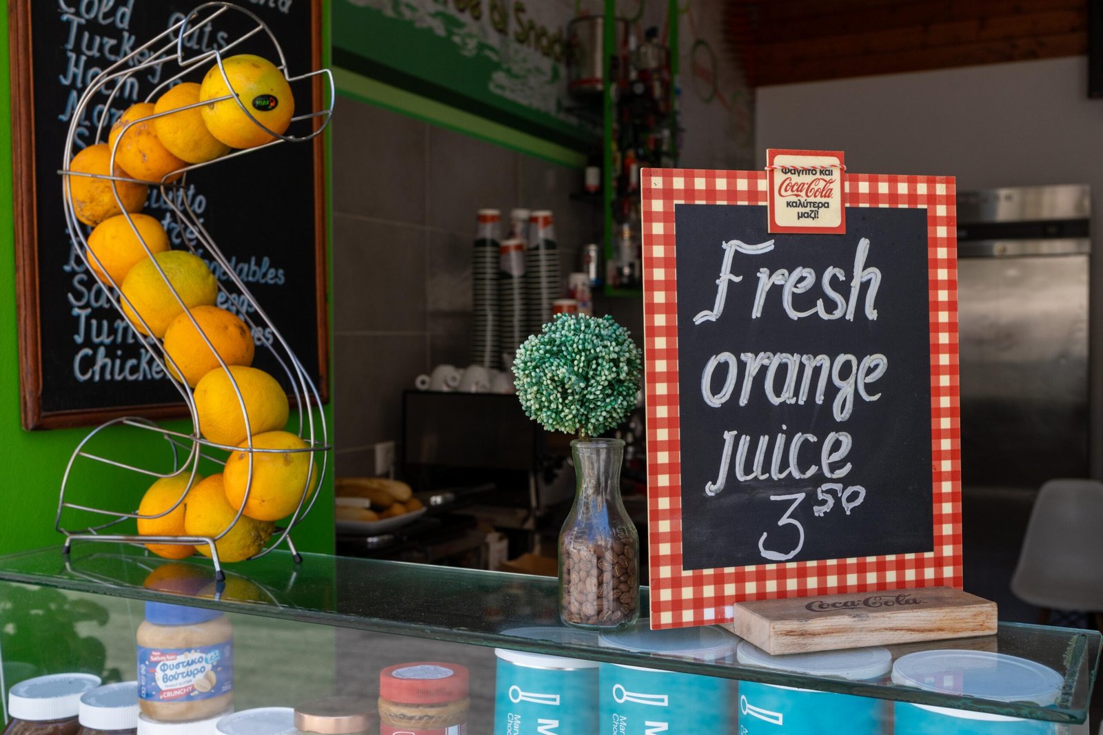 Fresh oranges on a spiral juicer stand next to a Fresh Orange Juice chalkboard sign at Terrace Coffee & Snacks
