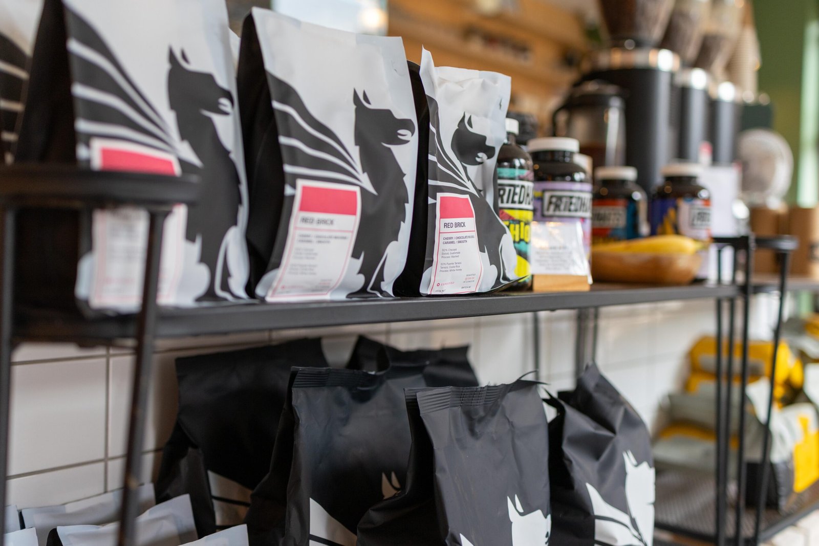 Red Brick house blend bags on the shelf at Velasquez and Van Wezel, each printed with a distinctive alpaca silhouette