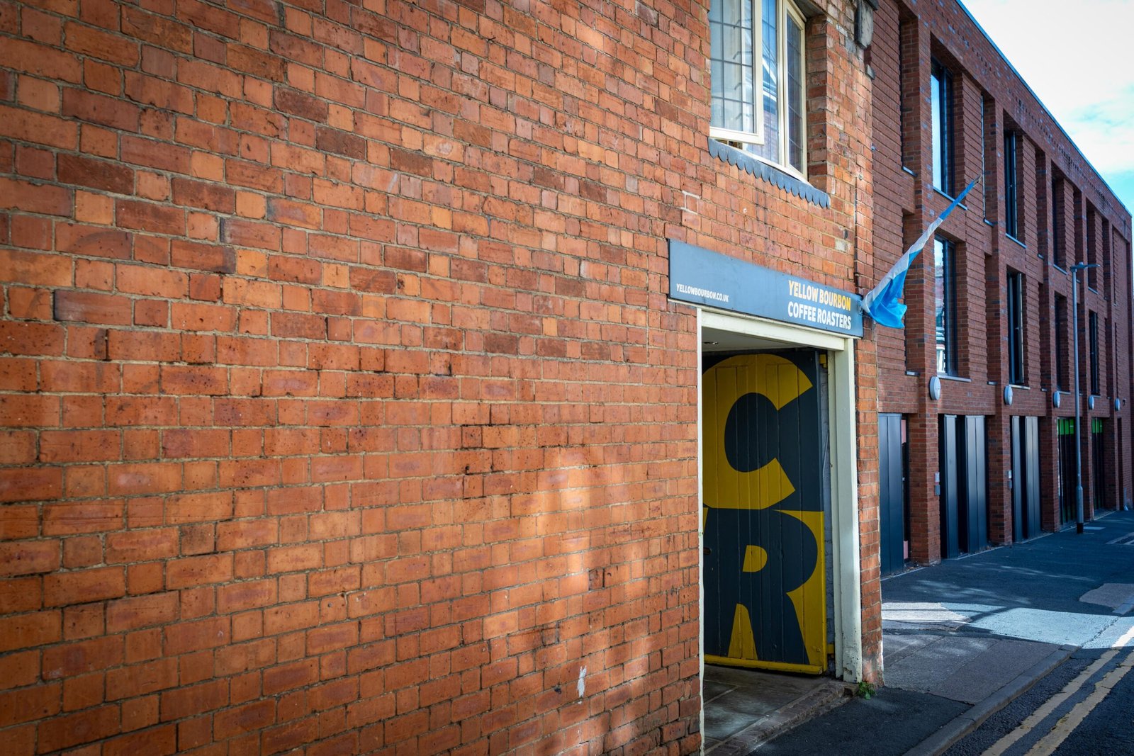 The Yellow Bourbon entrance on Angel Street, a bold yellow-and-black door tucked into weathered brickwork