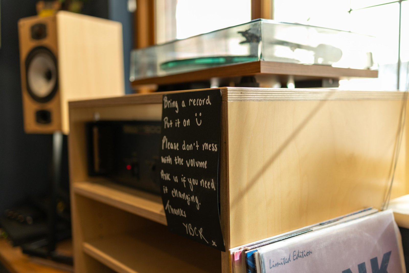 A handwritten sign inviting customers to bring a record and play it at Yellow Bourbon