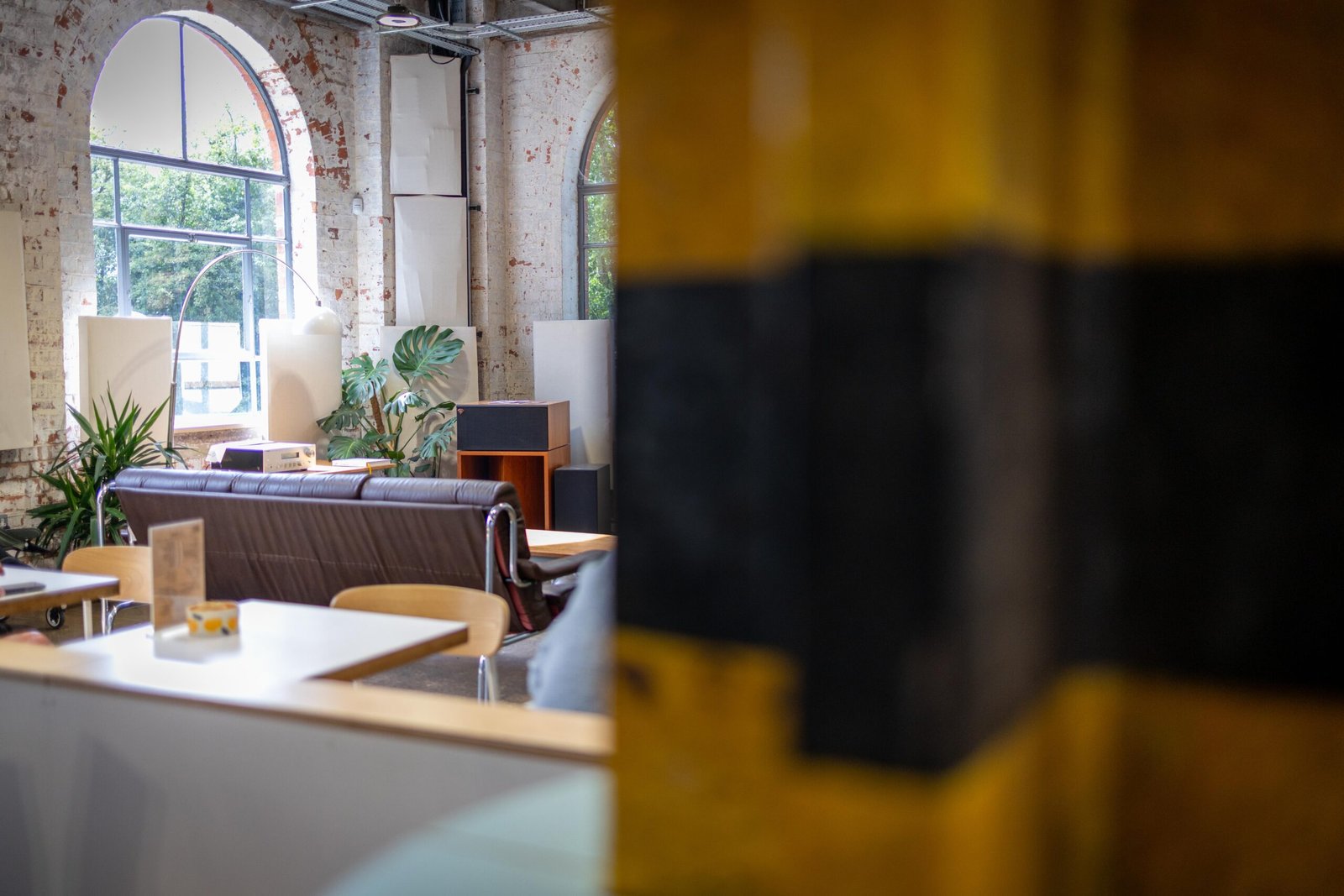 The cosy seating area at Yellow Bourbon's Weedon Depot, with a leather sofa and arched windows