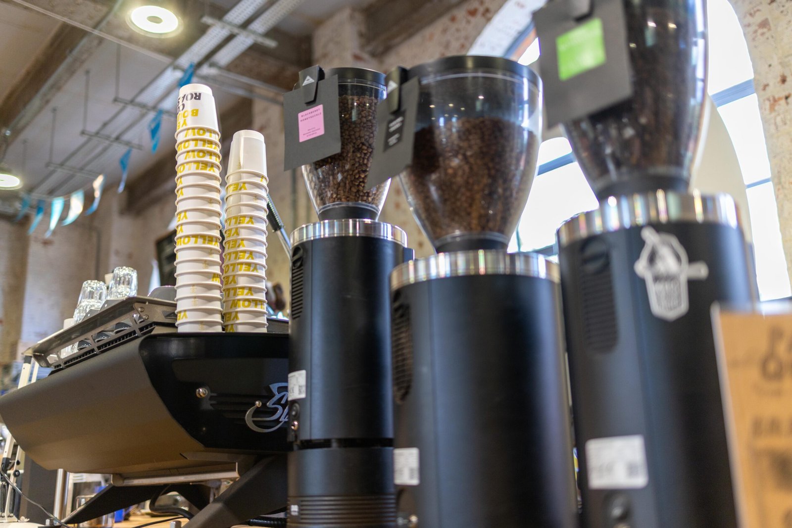 Coffee grinders and branded cups on the counter at Yellow Bourbon's Weedon Depot