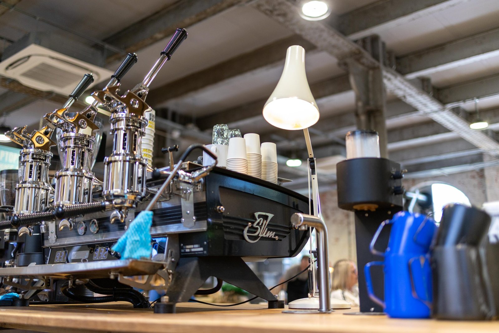 The espresso machine at Yellow Bourbon's Weedon Depot, with customers seated in the background