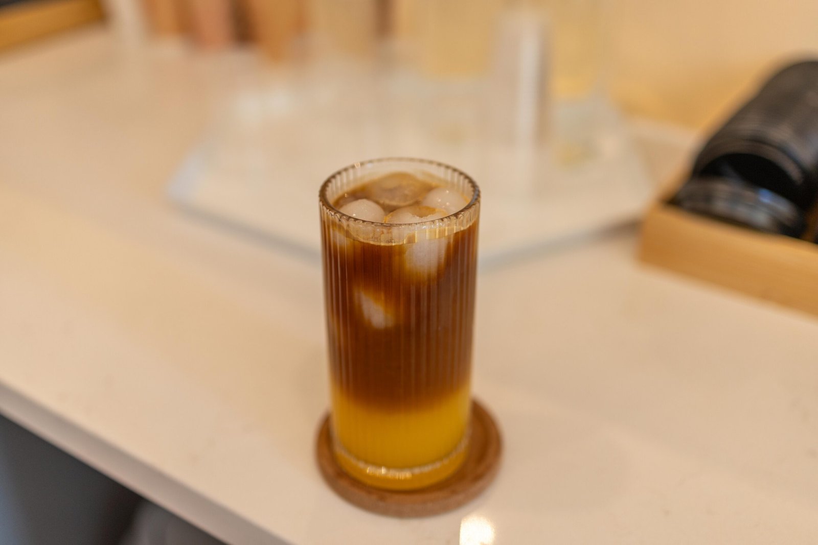 A Bumble served in a ribbed glass, with a dark coffee layer resting above a bright citrus base
