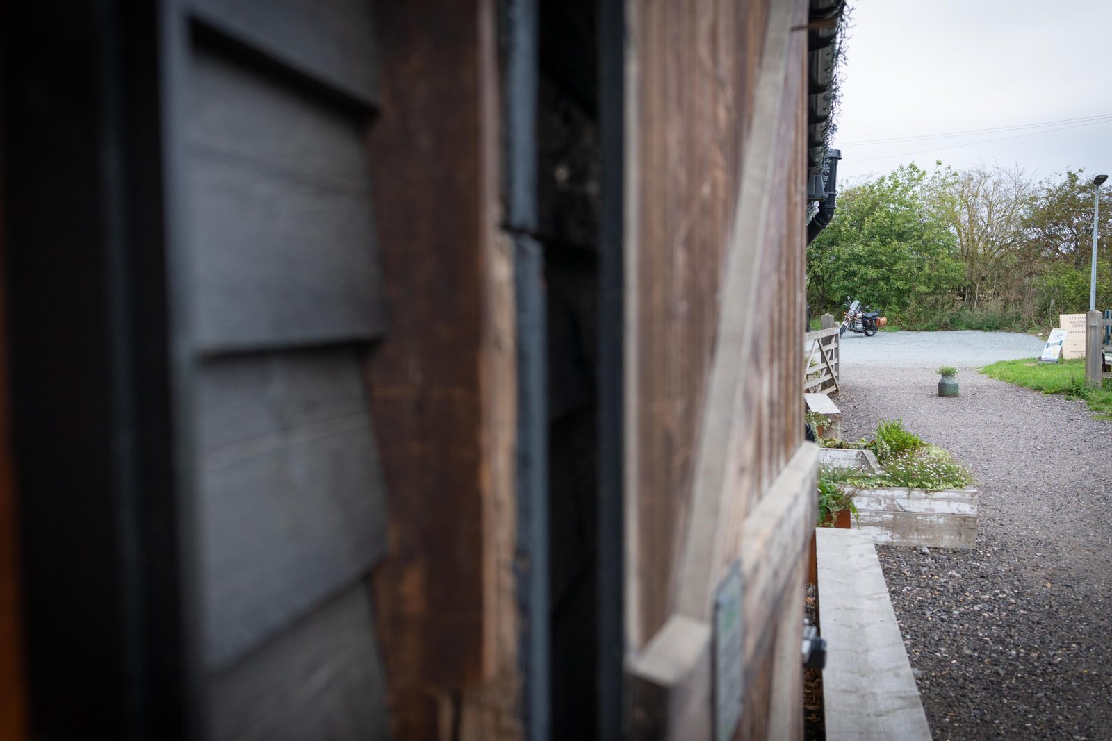 A view through the barn doorway at Wooden Hill Haynes toward the gravel car park