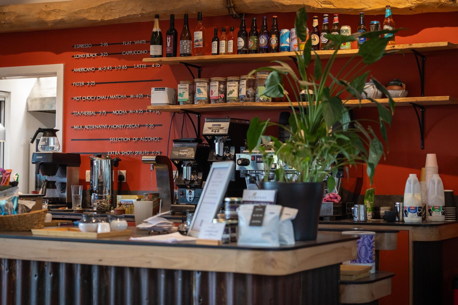 The coffee menu and espresso bar at The Mixing Shed Cafe, painted on a terracotta wall