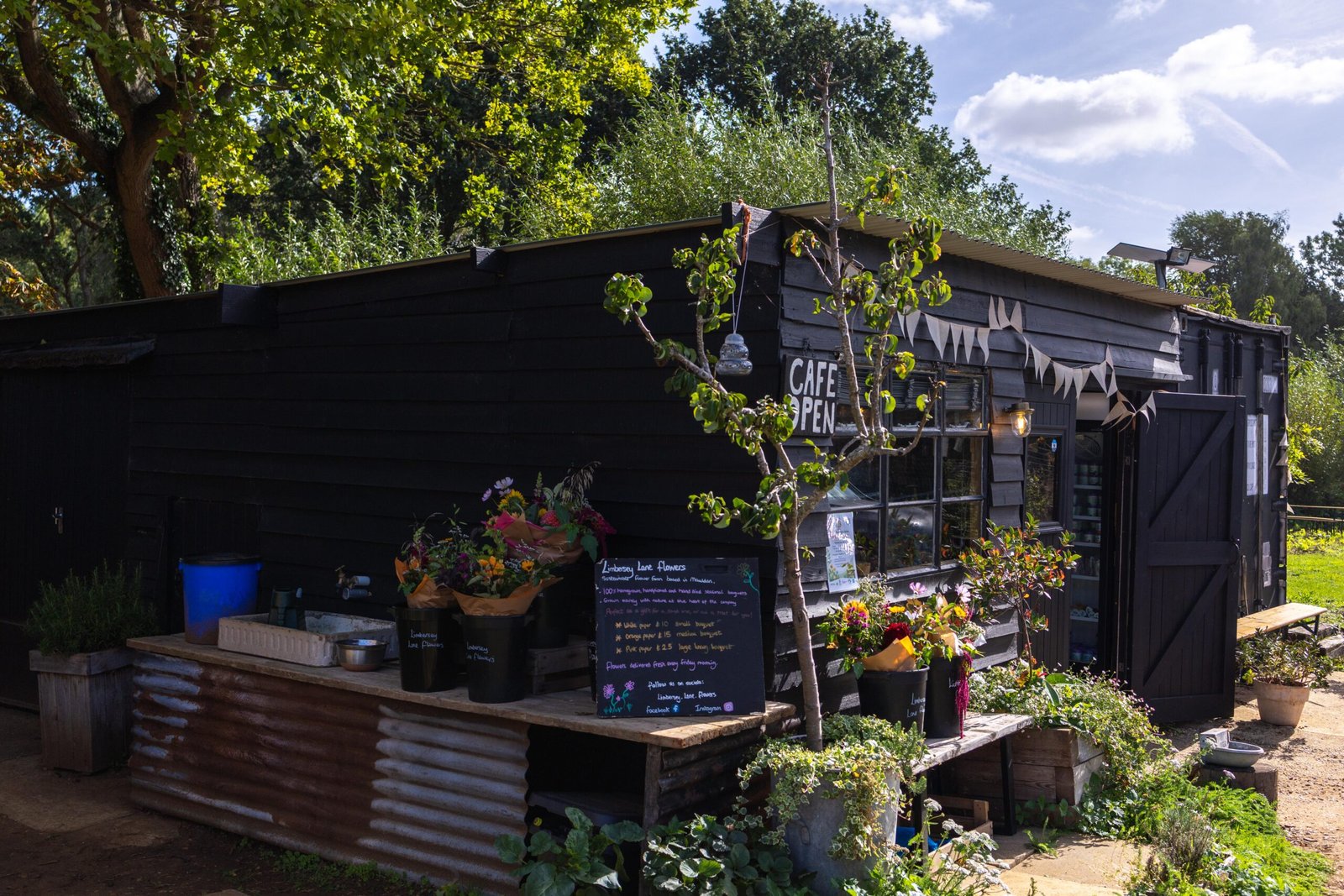 The converted bait shed exterior at Wooden Hill's Maulden cafe, with a local flower stand outside
