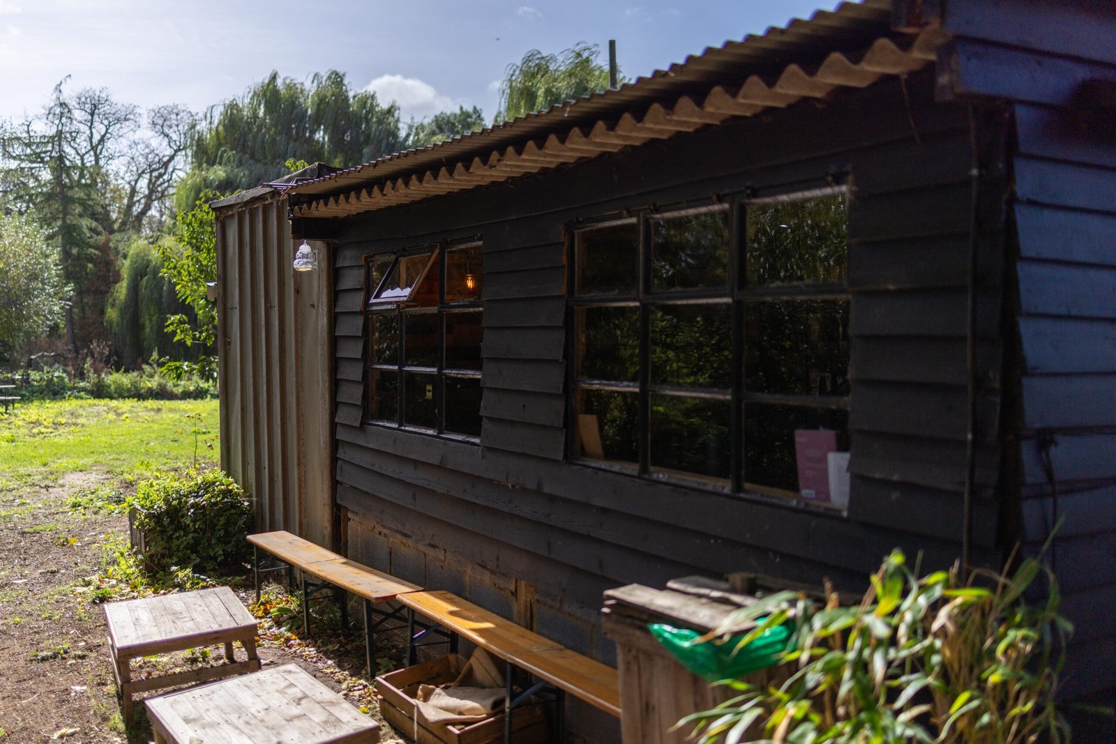 Side view of the Wooden Hill Maulden cafe showing salvaged windows and picnic bench seating