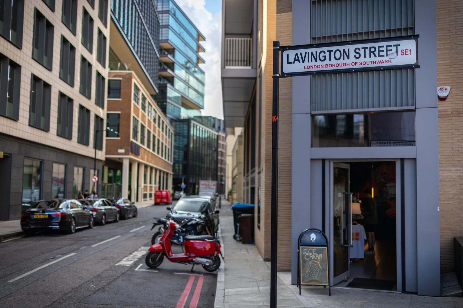 The Lavington Street sign in Southwark outside Saint Nine Coffee, with motorcycles and scooters parked in the dedicated bike bay