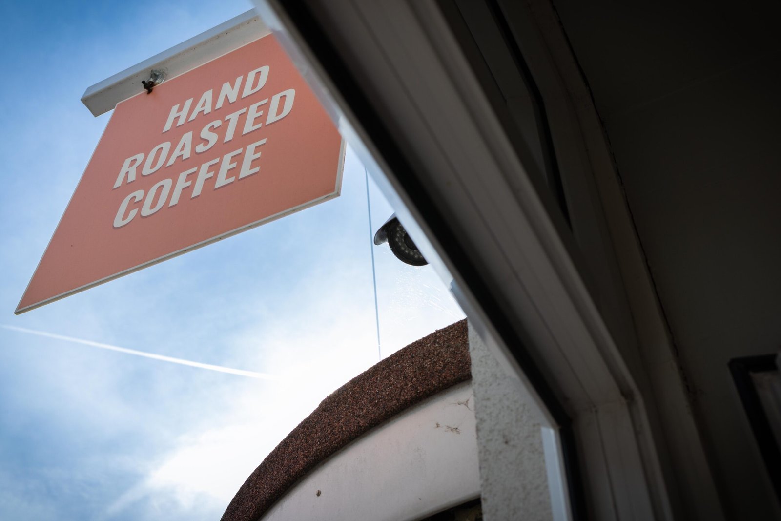 The orange hanging sign reading Hand Roasted Coffee, one of the top coffee stops in Watford