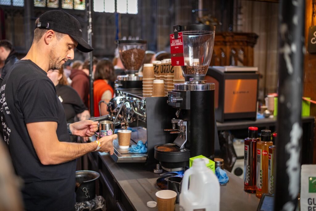 Barista in a black cap preparing a coffee at the 200 Degrees Coffee stand