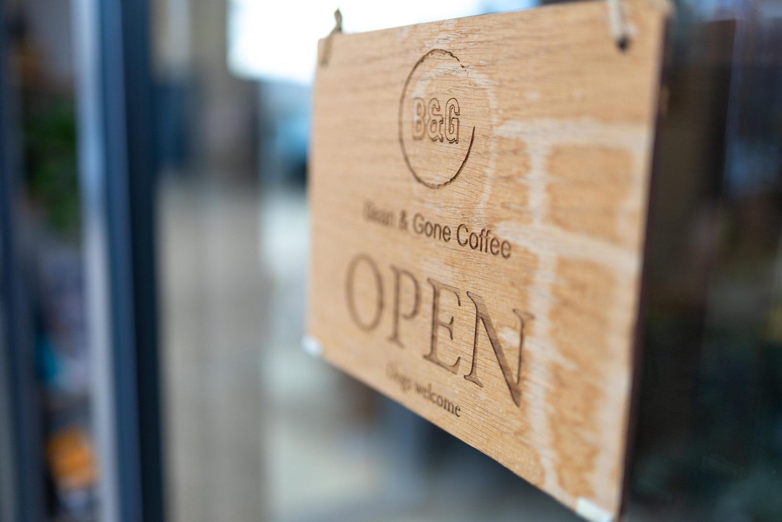 Wooden hanging sign reading Open at Bean & Gone Coffee in Hertford