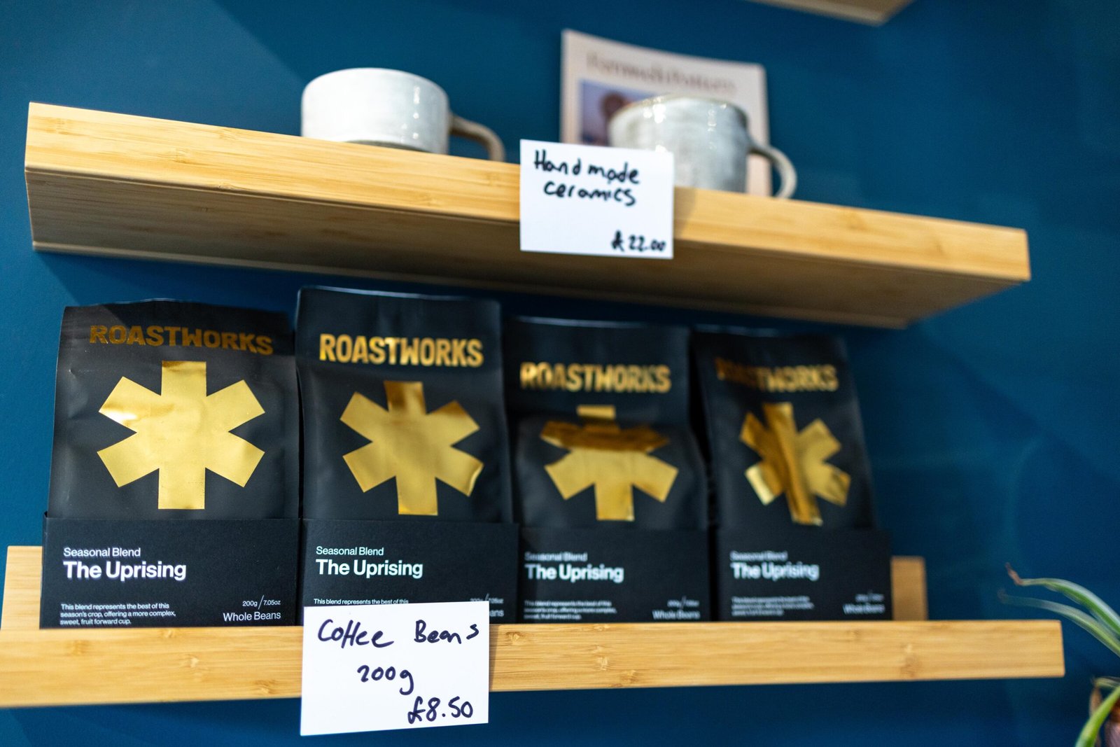 Shelves of Roastworks coffee beans and handmade ceramics at Bean & Gone Coffee