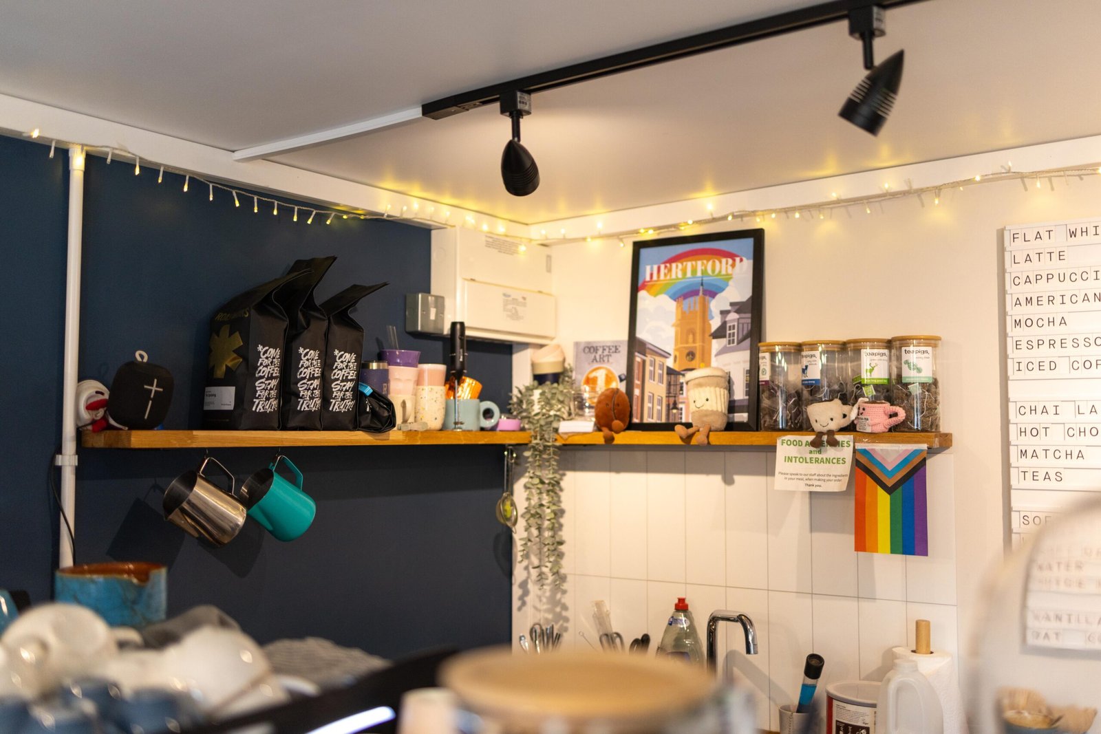 Counter shelf with mugs, coffee bags and a chalkboard menu inside Bean & Gone Coffee