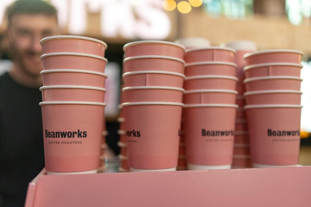 Stacks of pink Beanworks Coffee Roasters paper cups on the counter