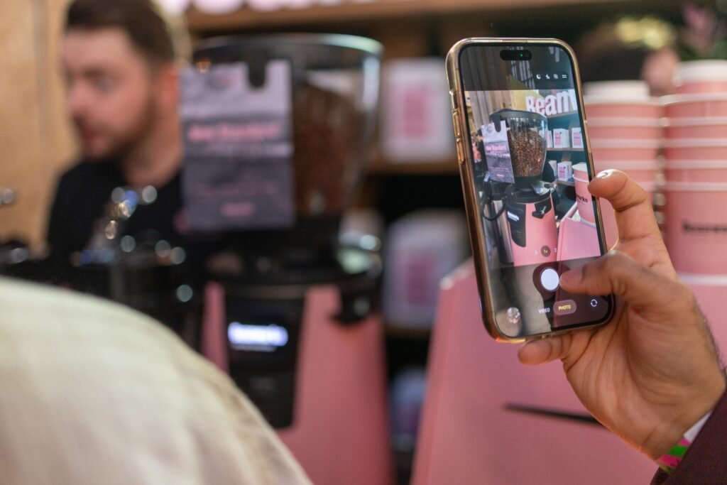 Visitor photographing the pink Beanworks grinder and cups on a phone