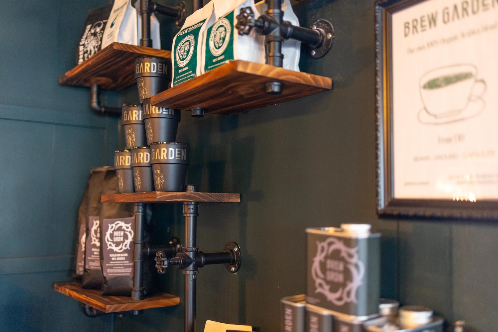 Shelves of coffee tins and bags against a dark green wall at Brew Garden