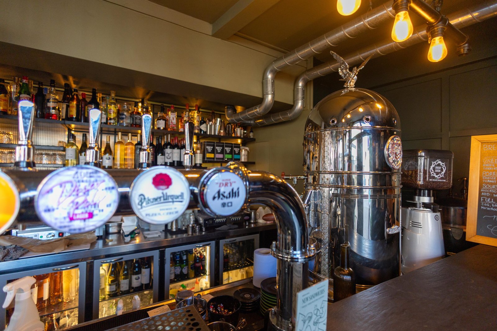 The bar at Brew Garden with beer taps and shelves of bottles