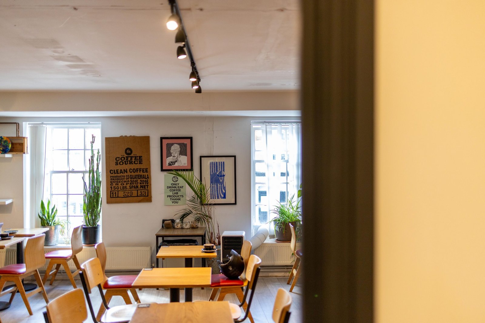 Co-working area upstairs at Coffee Lab with wooden tables and sash windows