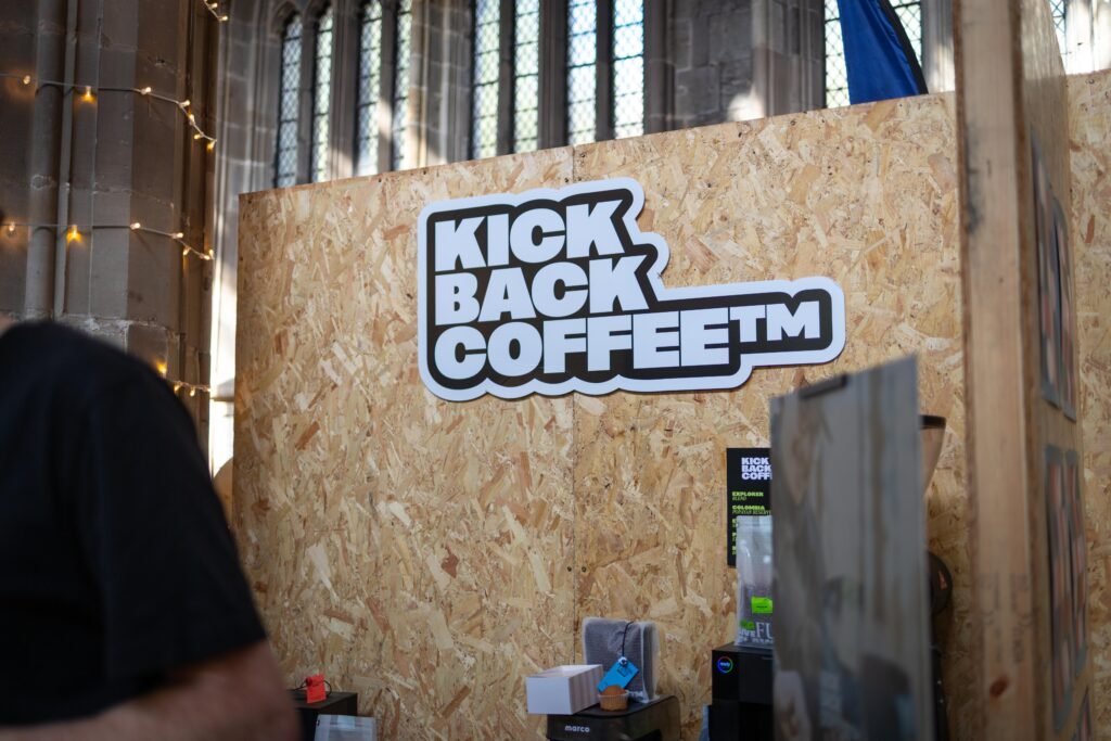 The Kickback Coffee logo on a wooden board at the stand
