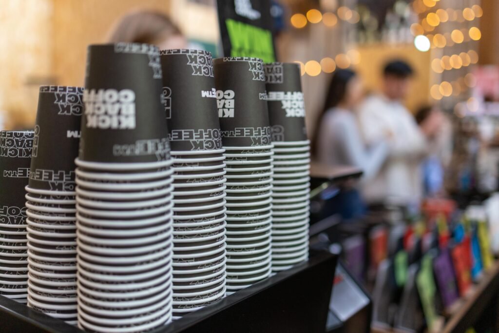 Rows of Kickback Coffee cups with the busy festival hall in soft focus behind