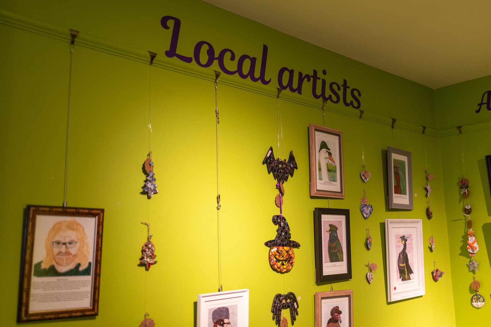 Local artists wall with framed pictures inside Mudlarks Garden Cafe
