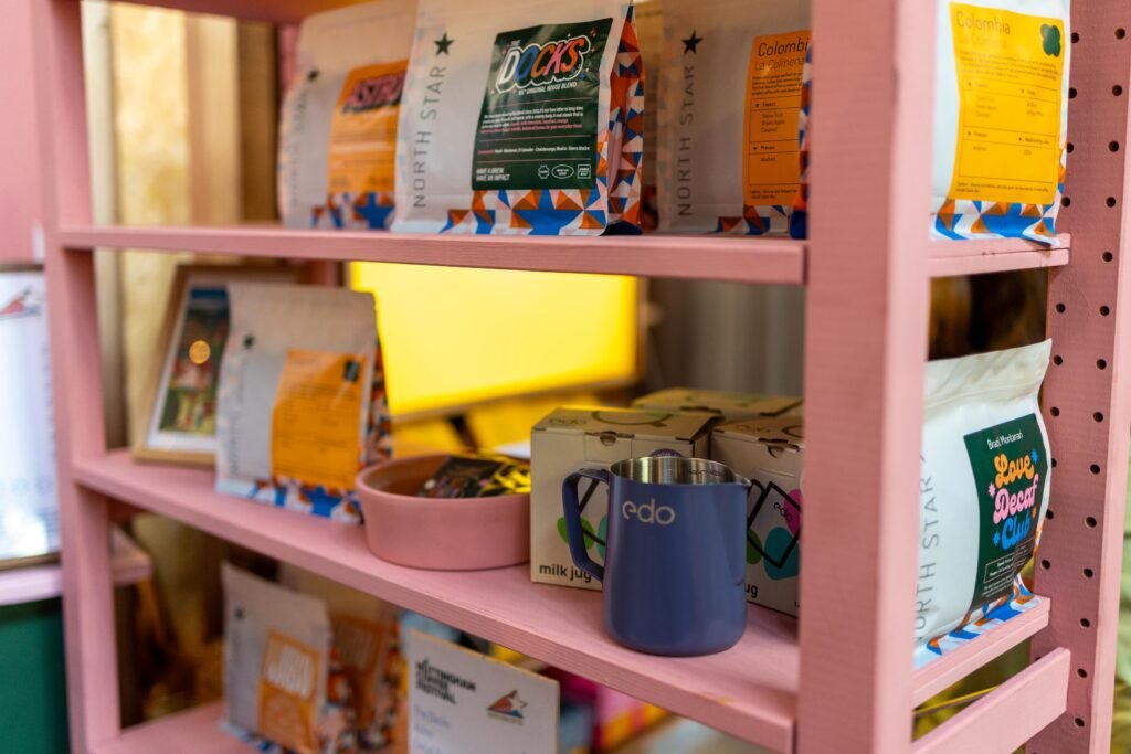 Shelves of North Star Coffee bags, a milk jug and menus on pink shelving