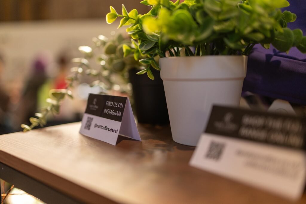Instagram QR code sign beside a small plant on the Nott Coffee stand