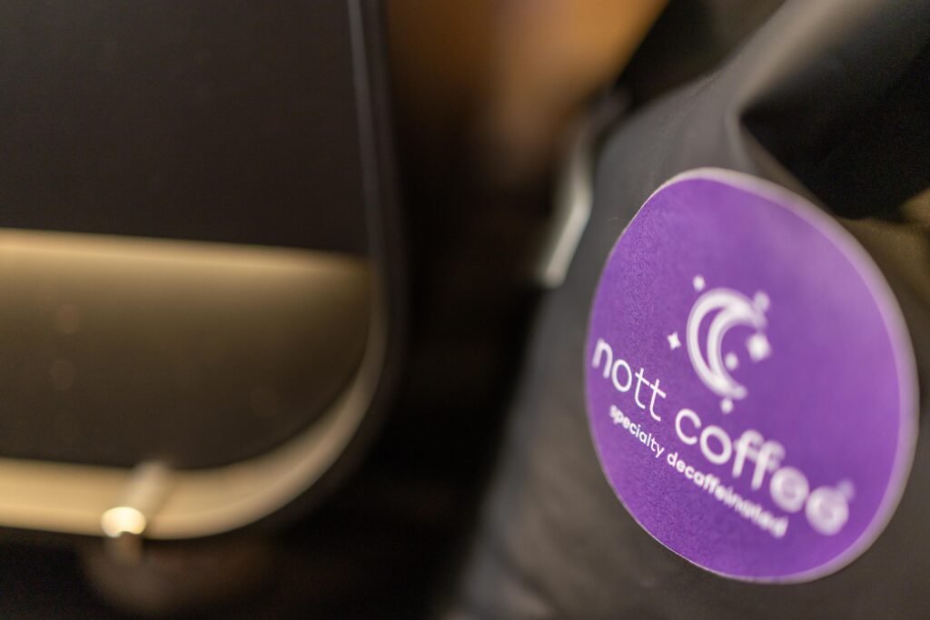 Purple Nott Coffee Specialty Decaffeinated sticker on dark clothing