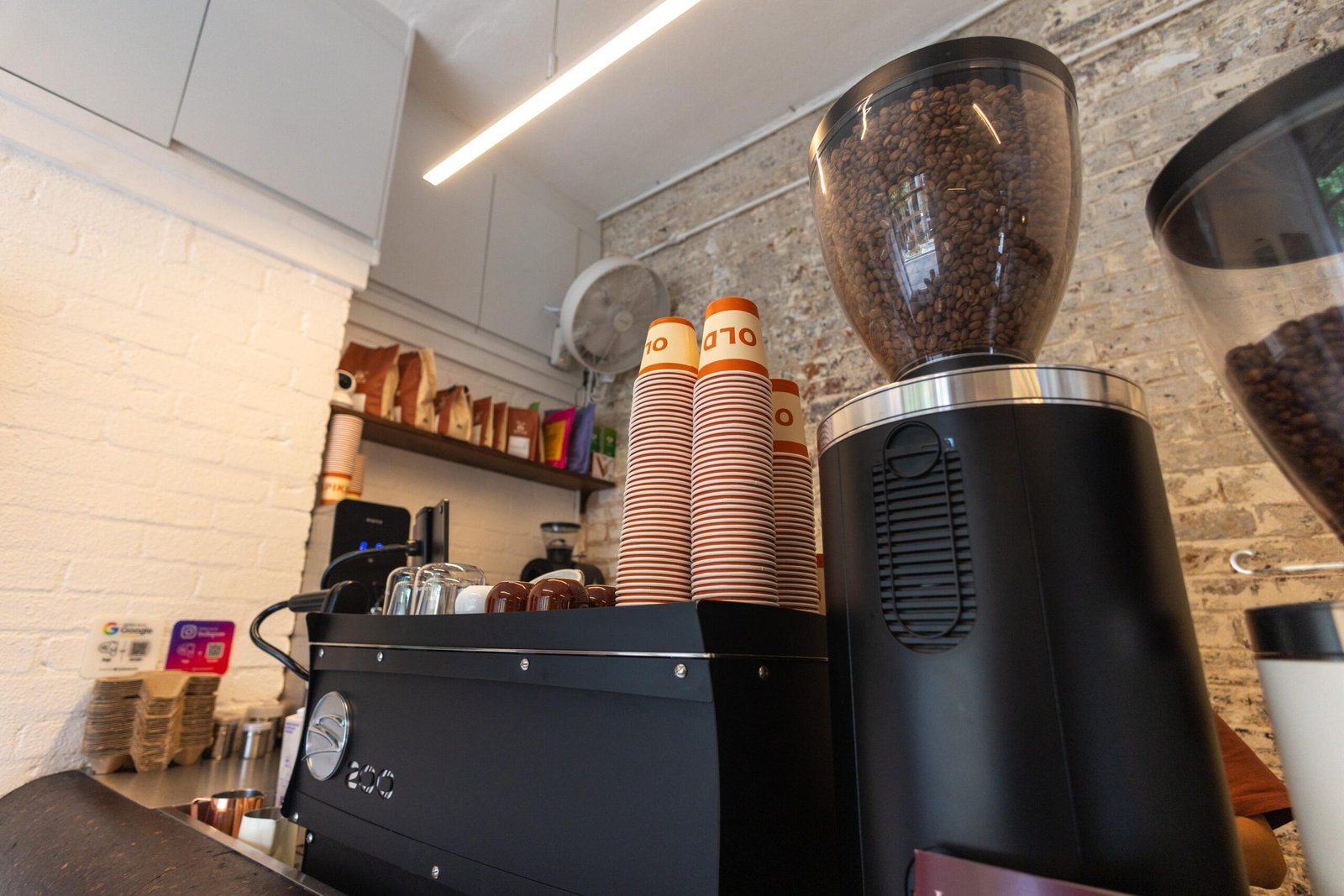 Espresso machine, grinder and stacked cups behind the bar at Old Spike