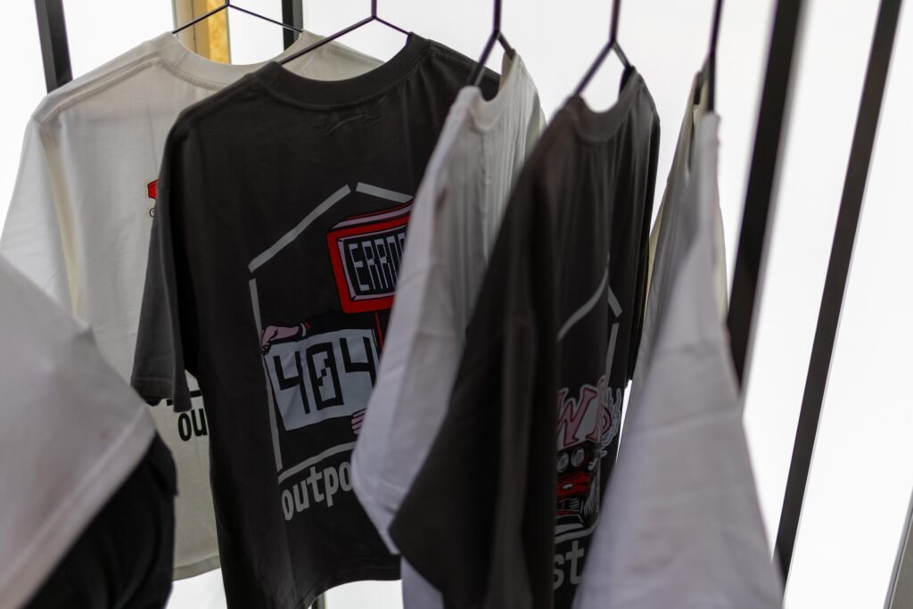 Outpost Coffee T-shirts hanging on a rail at the stand