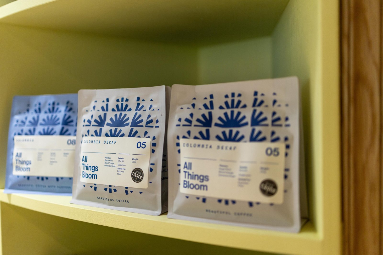 Bags of All Things Bloom coffee on a shelf at Proto Artisan Bakery